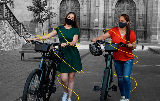 mujeres caminando con sus bicicletas eléctricas