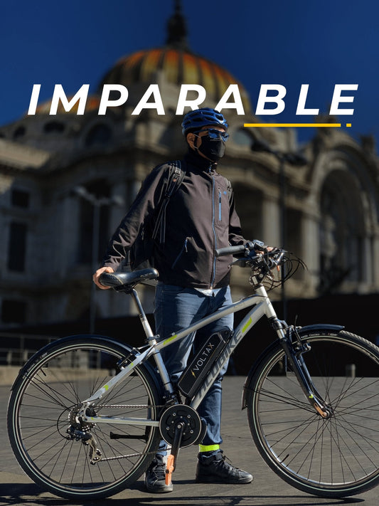 hombre con cubrebocas y gafas oscuras a lado de una bicicleta eléctrica