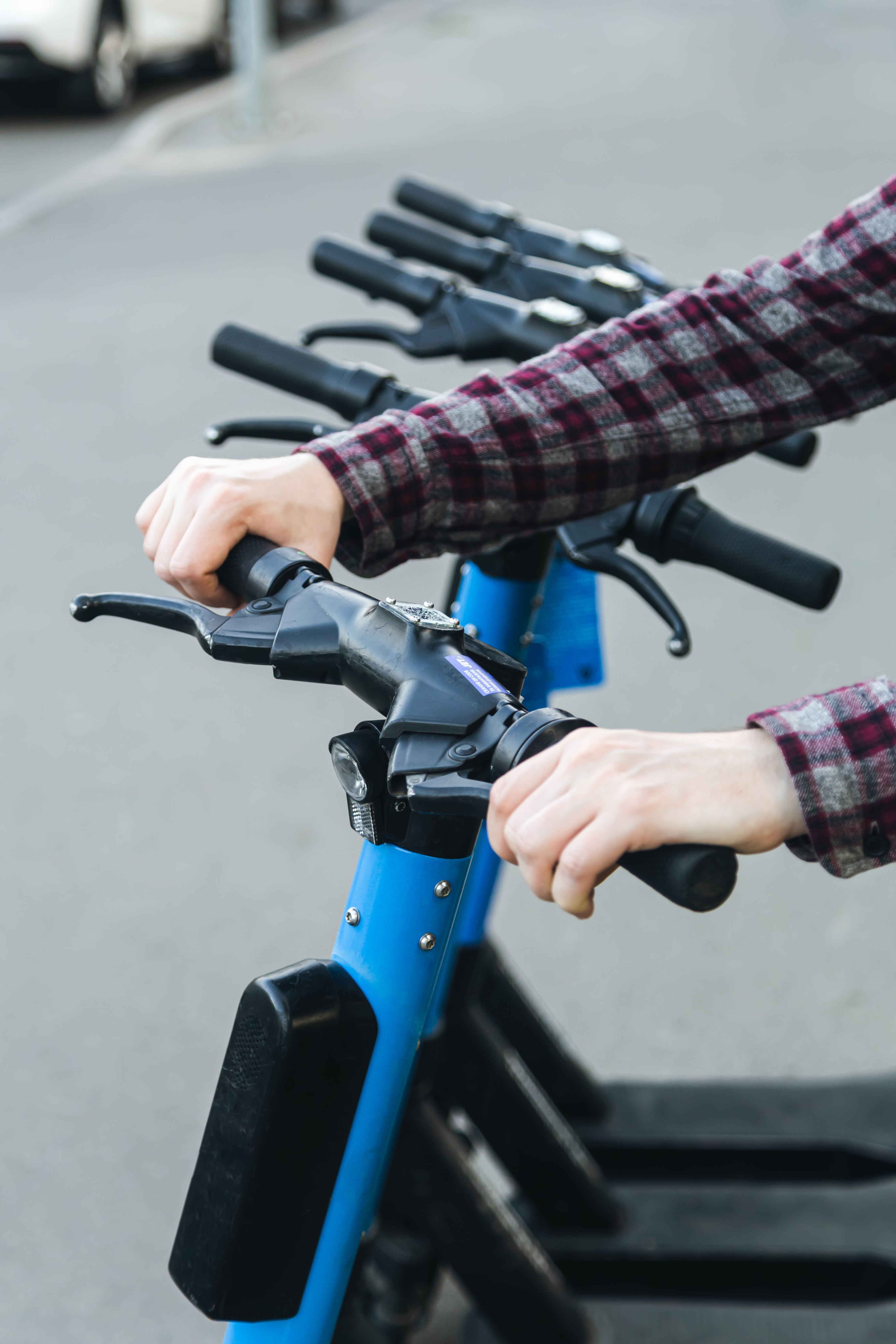 Linea de scooters electronicos y un hombre sosteniendo uno